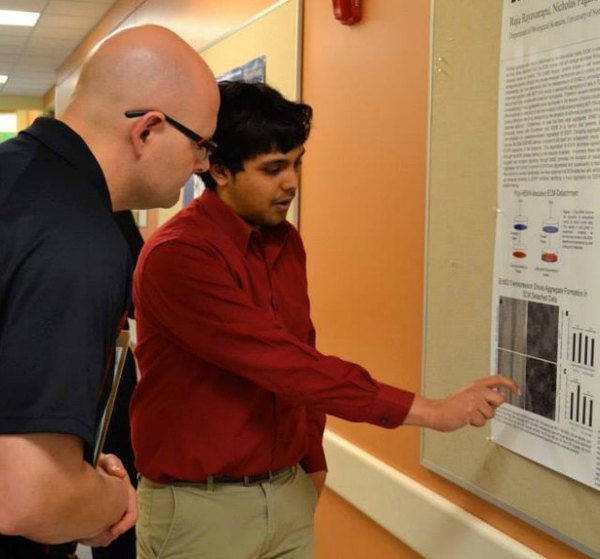 Graduate student Raju Rayavarapu presents the findings on his research to one of the day's judges