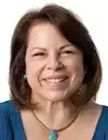 Middle-aged woman with short brown hair, blue shirt, and white background.